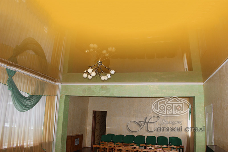 натяжні стелі жовтого кольору в залі